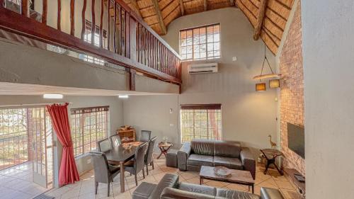 a large living room with a table and chairs at Walking Tall Private Bush Retreat in Marloth Park
