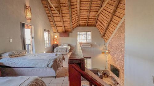 1 dormitorio con 2 camas y techo de madera en Walking Tall Private Bush Retreat en Marloth Park