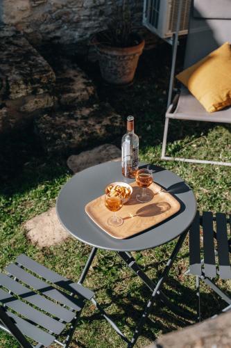 - une table avec une bouteille et deux verres dans l'établissement Un chambre à la campagne, à Saint-Cyprien