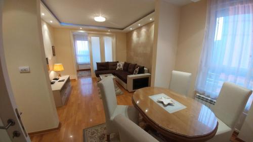 a living room with a table and a couch at Delta Residence Belville in Belgrade