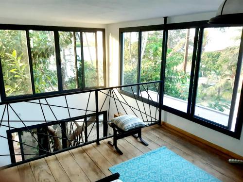 een kamer met een trap met ramen en een bank bij Mon paradis in Saint-Louis