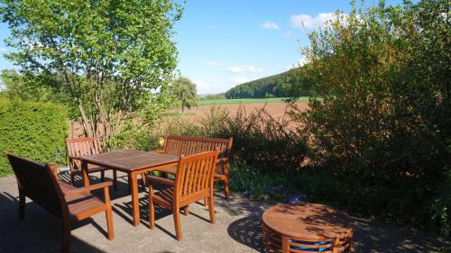 un patio con mesa, sillas y un campo en Blockhaus en Anraff