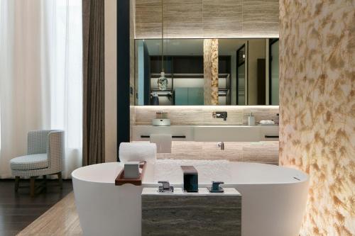 La salle de bains est pourvue d'un lavabo blanc et d'un miroir. dans l'établissement Zhengzhou The Grand House, à Zhengzhou