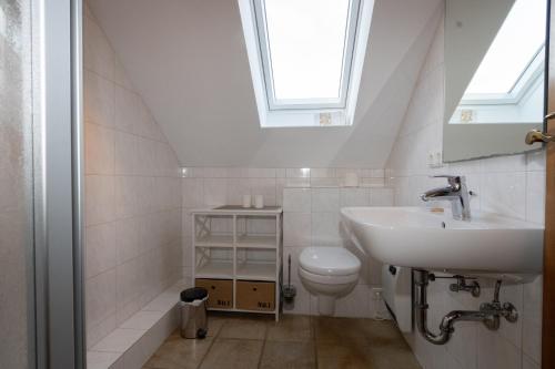 a bathroom with a sink and a toilet at Haus Möwe, Wohnung Matthäus in Hörnum