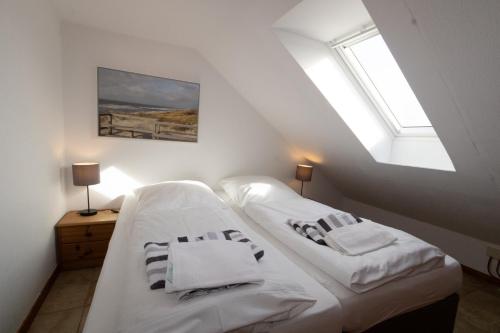 ヘルヌムにあるHaus Möwe, Wohnung Matthäusのベッドルーム1室(白いシーツが備わるベッド2台、窓付)