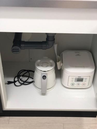 a microwave and a toaster sitting on a shelf at Apartment Heights HANA in Sakai