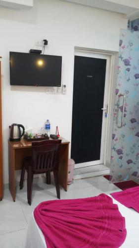 a bedroom with a desk and a table and a television at WISH RESIDENCE SeaSide, Near Durdans & Vasan eye care Hospital, Colombo 3 in Colombo