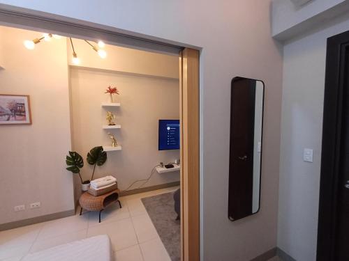 Habitación con espejo y puerta con TV. en Newpointe suite, en Manila