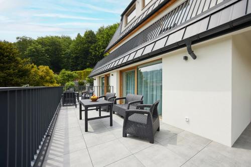 a patio with chairs and a table on a balcony at EveRest Apartamenty Szczyrk in Szczyrk