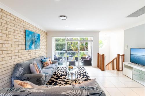 a living room with a couch and a tv at 1 75 Rocky Point Road fantastic holiday home with in Fingal Bay
