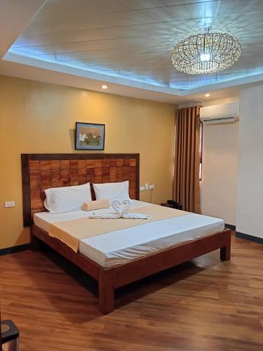 a large bed in a bedroom with a chandelier at Norlu Cedec Midpoint Hotel in Rosario