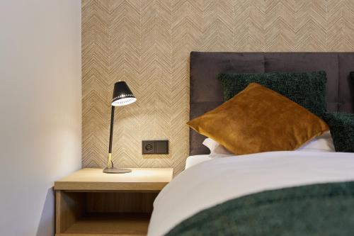 a bedroom with a bed and a lamp on a night stand at EveRest Apartamenty Szczyrk in Szczyrk