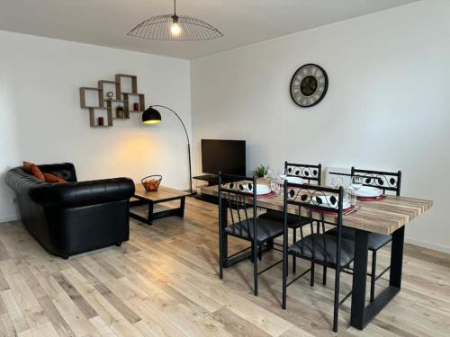 uma sala de estar com uma mesa e um sofá em Appartement Cosy em Louhans