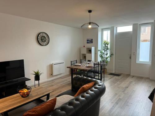 uma sala de estar com um sofá de couro e uma mesa em Appartement Cosy em Louhans