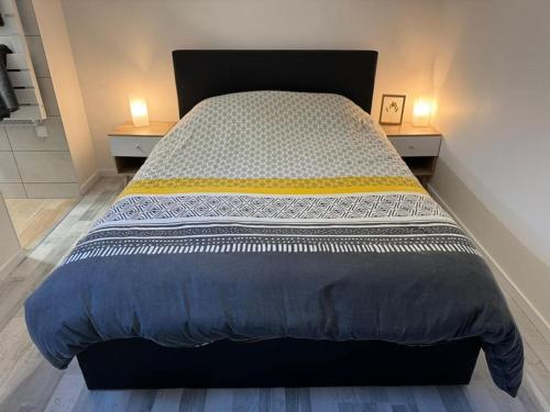 uma cama grande num quarto com duas mesas de cabeceira em Appartement Cosy em Louhans
