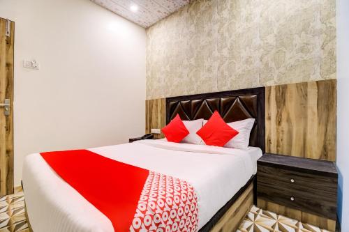 1 dormitorio con 1 cama grande con almohadas rojas en OYO Flagship Hotel Qubic, en Bombay