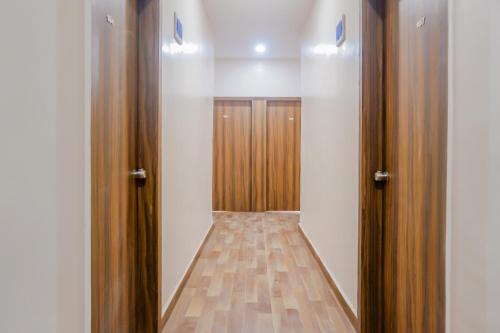 an empty closet with wooden doors in a room at Collection O Hotel Rest Inn in Yeraoda