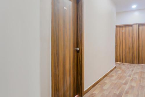 a room with a closet with a wooden door at Collection O Hotel Rest Inn in Yeraoda