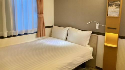 a small bed in a room with a window at Toyoko Inn Sendai Higashi-guchi No 2 in Sendai