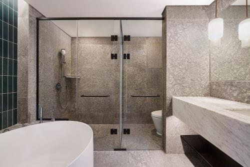 a bathroom with a shower and a sink and a toilet at Naru Ambassador Hotel Seoul - MGallery Collection in Seoul