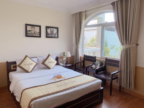 una stanza d'albergo con un letto e una finestra di Boulevard Phú Quốc PQ - by BAY LUXURY a Phu Quoc