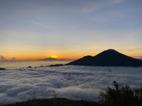 a view of the sun rising over a sea of clouds at Mount Batur longtrip in Kubupenlokan