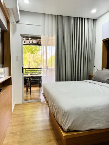 a bedroom with a bed and a sliding glass door at Stylish Staycation near BGC w/ Home Cinema in Manila