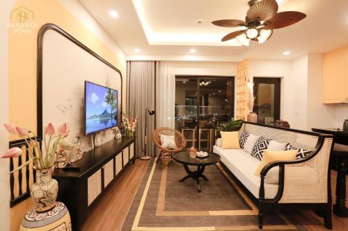 een woonkamer met een bank en een tv bij FLC Sea Tower Quy Nhơn- Đông Ngô House in Quy Nhon