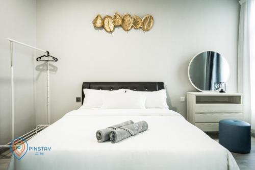 a bedroom with a bed with a camera on it at Jesselton Quay by Pinstay in Kota Kinabalu