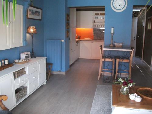 una cucina con pareti blu, tavolo e bancone di Apartment Het Demerhuisje a Hasselt