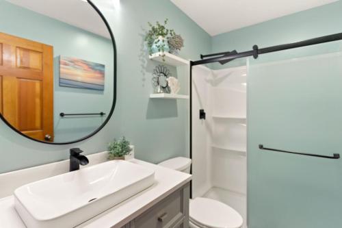 a bathroom with a sink and a mirror at QCB5 Saltaire Sunrise Oceanfront in Nags Head
