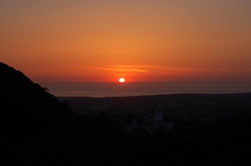 a sunset with the sun setting in the distance at Isa's Home in Sintra