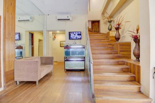 a staircase in a hospital with a couch and a chair at OYO Hotel Address Inn in Mumbai