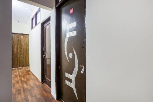 um corredor com uma porta com escrita branca em OYO Perfect Inn em Nova Deli