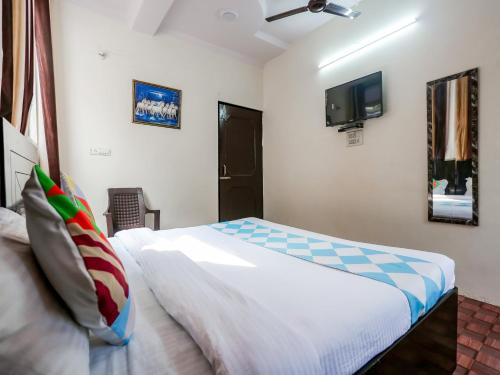 um quarto com uma cama e uma televisão na parede em OYO Perfect Inn em Nova Deli