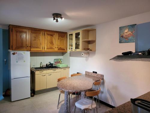 une petite cuisine avec une table et un réfrigérateur dans l'établissement Maison 4 face a la mer grand Jardin Ideal Famille avec pluri Animaux Saint Clair Le Lavandou, au Lavandou