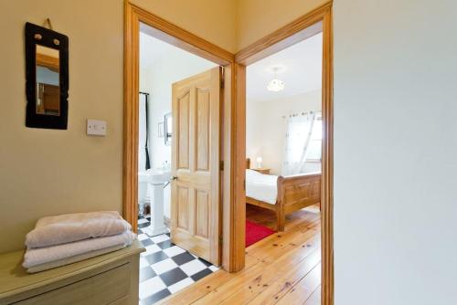 a bathroom with a door leading to a bedroom at Ash House Bed and Breakfast in Calverstown