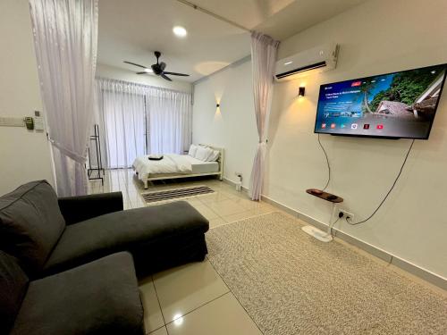 sala de estar con sofá y TV de pantalla plana en The Borneo Suite - For group of 6 en Kota Kinabalu