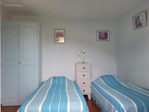1 Schlafzimmer mit 2 Betten und einer Kommode in der Unterkunft Maison 4 face a la mer grand Jardin Ideal Famille avec pluri Animaux Saint Clair Le Lavandou in Le Lavandou