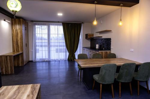 - une salle à manger avec une table et des chaises en bois dans l'établissement Villa Ipanema, à Telavi