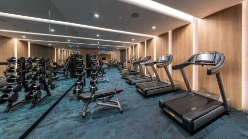 a gym with a row of exercise bikes and treadmills at Crowne Plaza Changi Airport by IHG in Singapore