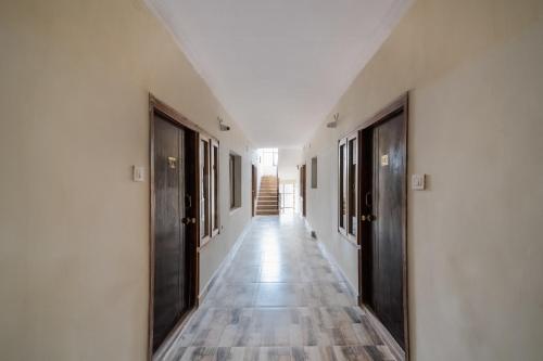 an empty hallway with doors and wooden floors at OYO Seera Enclave in Rājahmundry