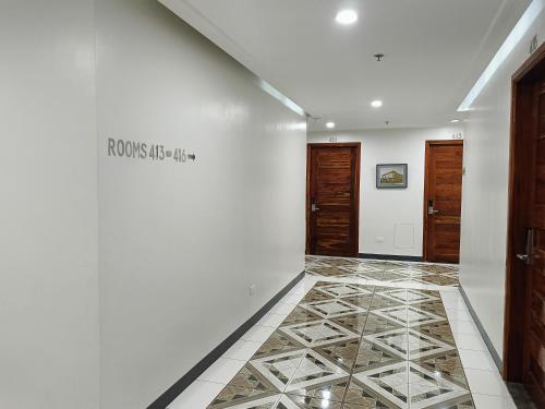 a hallway with a white wall and a tile floor at Norlu Cedec Midpoint Hotel in Rosario