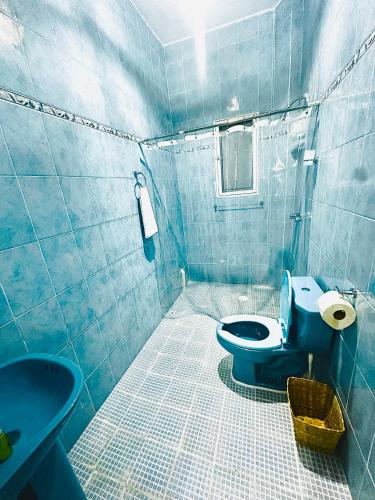 a blue tiled bathroom with a toilet and a sink at La Casa de Colores Ocean View in Puerto Ángel