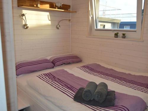 Una cama con dos almohadas encima. en Houseboat Hecht in Egernsund at the Marina Minde en Egernsund