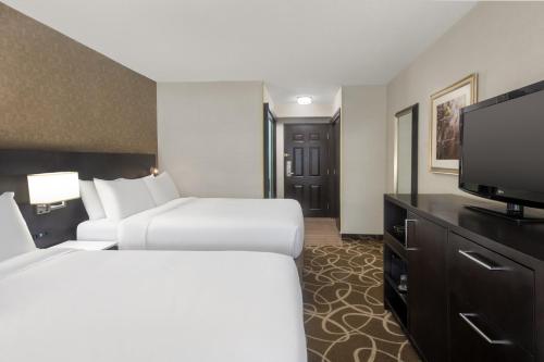 a hotel room with two beds and a flat screen tv at Crowne Plaza Kitchener-Waterloo by IHG in Kitchener