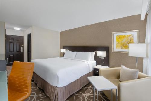 a hotel room with a large bed and a couch at Crowne Plaza Kitchener-Waterloo by IHG in Kitchener