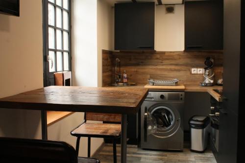 une cuisine avec une table et une machine à laver dans l'établissement LOFT 8, à Douai