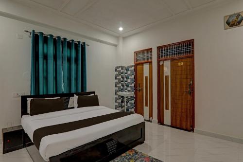 OYO Flagship Hotel Aanandwan Palace في فاراناسي: غرفة نوم بسرير كبير مع ستائر زرقاء