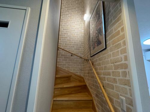 escalera con pared de ladrillo y suelo de madera en M&Y Ishigaki Island / 3 Bedroom House, en Nagura